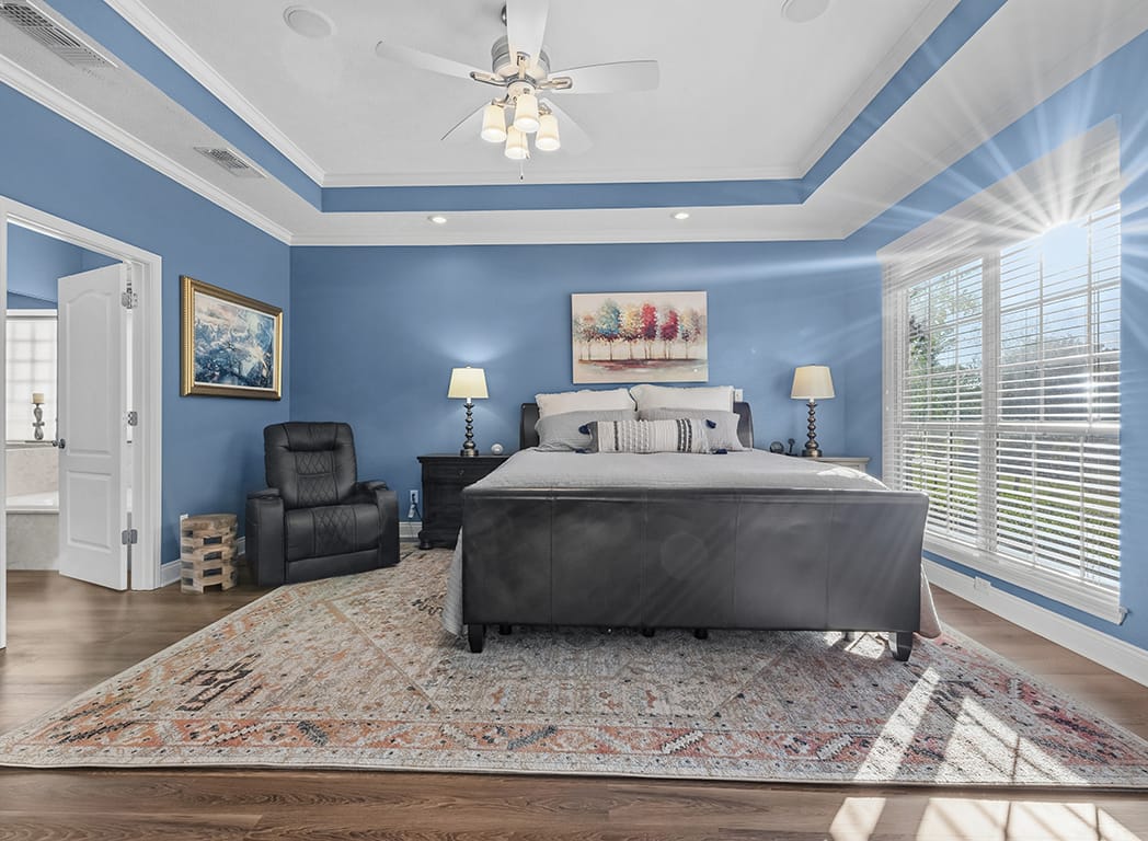 Primary Bedroom with Blue Walls and Ceiling Fan Sun Setting Real Estate Photos