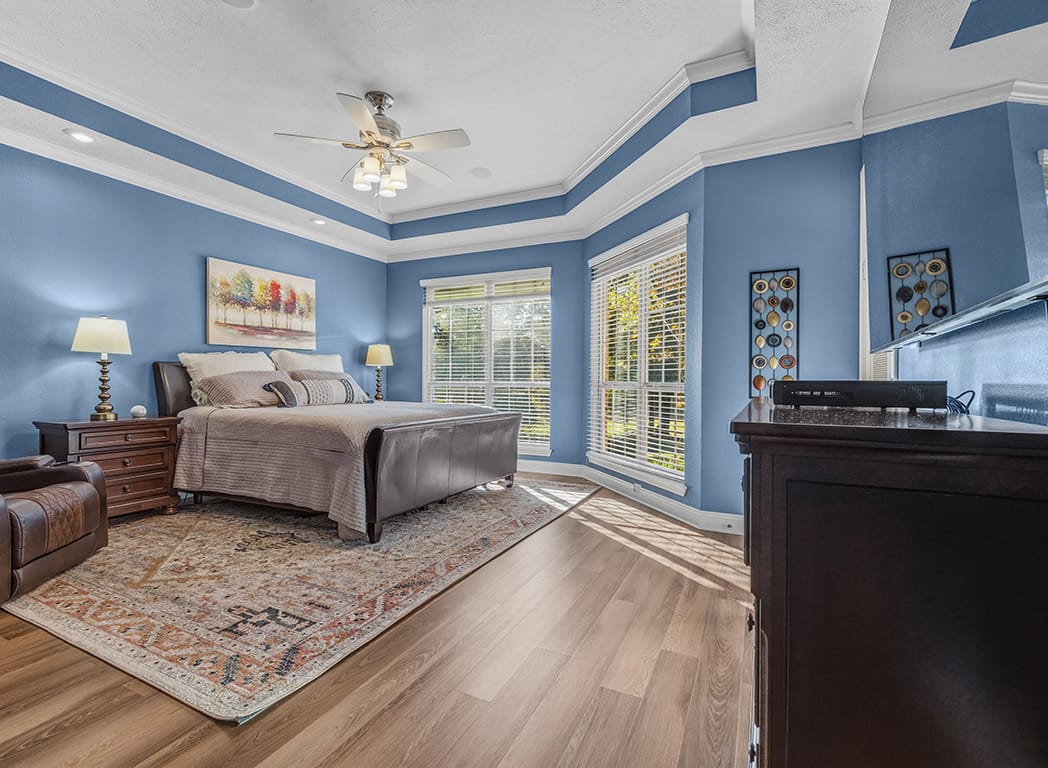 Primary Bedroom with Blue Walls and Ceiling Fan